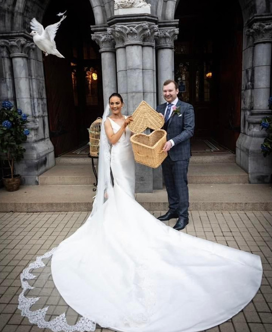 A wedding couple releasing a dove from a heart shaped basket.